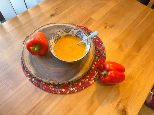 Bowl of warm carrot soup on dining table ready to eat.